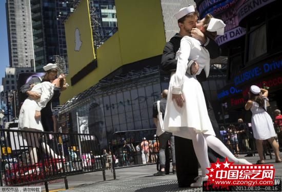 资料图：美国纽约，情侣穿着水兵和护士的服装在时代广场接吻，重现“胜利日之吻”。
